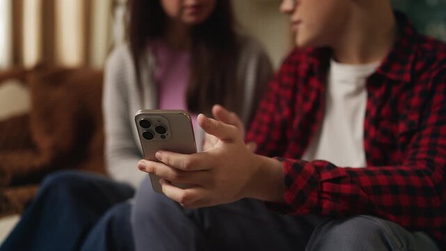 Teenage boy helping his mother set up a new phone application, modern technology