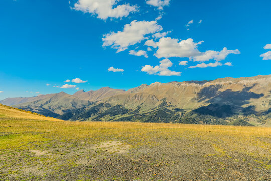 Horizontal sunny alpine mountain landscape with blue sky and clouds in Arkhyz Karachay Cherkessia Russia.