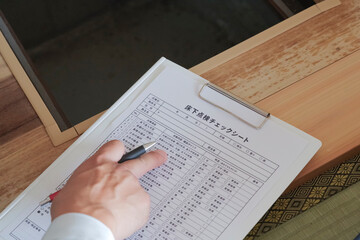 Obraz premium 床下点検口から床下を確認 する作業員