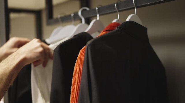 Male hands selecting clothes for a special occasion, choosing stylish jacket