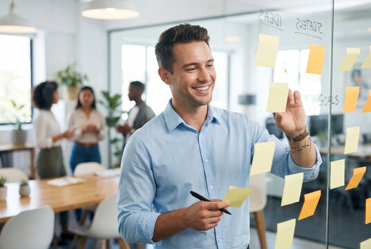 Businessman planning with sticky notes on glass