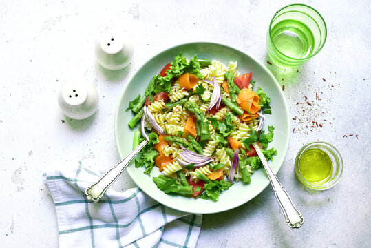 Pasta salad with vegetables : asparagus, tomatoes, carrot. Top view with copy space.