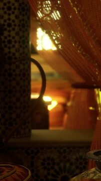 Light gently shines through colorful curtains in a warm indoor setting. The soft glow reflects off various objects, creating an inviting atmosphere during the evening.