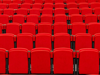 Obraz premium Full frame background of empty red velvet chairs in rows at a school assembly hall