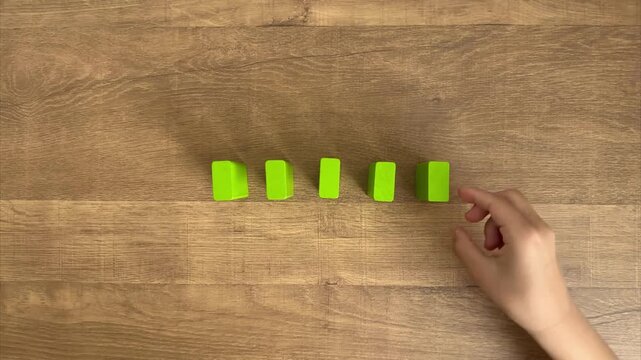 Child Hand Lines Up Five Yellow-Green Blocks and Knocks Them Down Like Dominoes, 4K