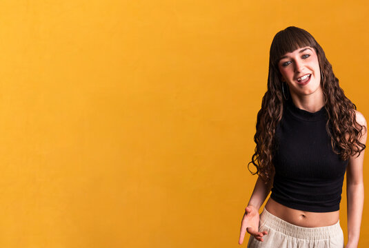 Happy woman dancing hip hop on yellow background