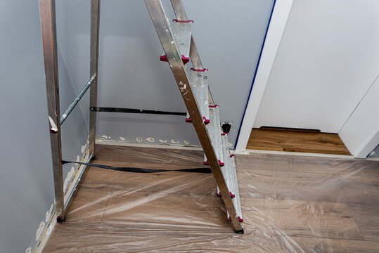 Room interior undergoing renovation with paint and ladder