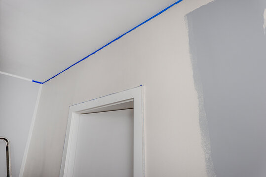 Renovating home interior with painter's tape and grey paint