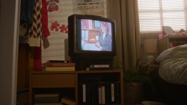 CRT television playing vintage footage in retro bedroom filled with nineties decor. Footage ideal for nostalgia marketing campaigns, historical documentaries, or retro technology reviews