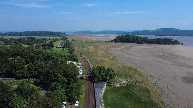 scenic aerial view of the coastline at Grange over Sands in Cumbria in summer with the railway line running along the shore at low tide