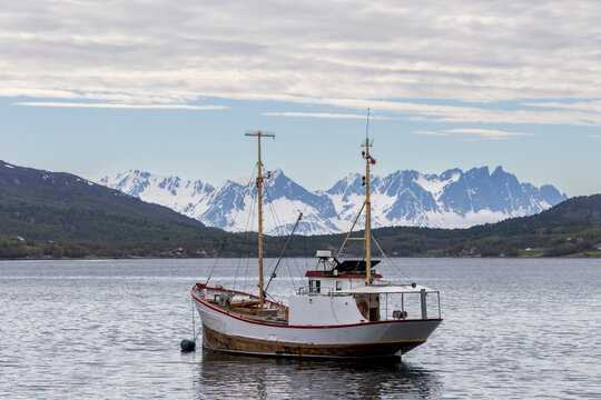 Fishing boat in the Burfjord in northern Norway. In the background Lyngen Alps in Troms County
