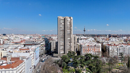 Fototapeta premium High-resolution drone photograph showcasing Madrid's skyline with residential neighborhoods, modern high-rise architecture and a bright blue sky filled with scattered clouds