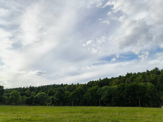 Naklejka premium Beautiful blue clouds on the blue sky over the green summer field