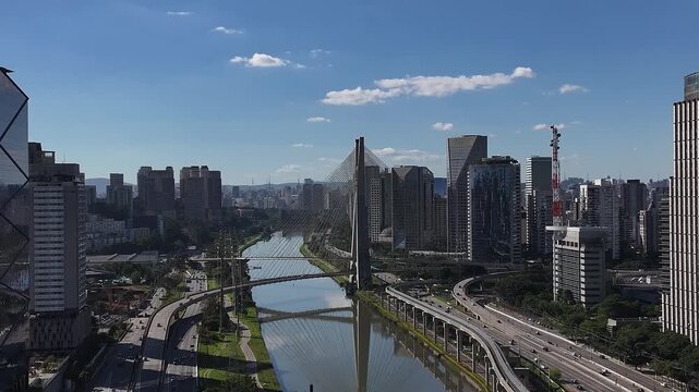 Aerial view of Oct&aacute;vio Frias de Oliveira Bridge over the Pinheiros River in S&atilde;o Paulo, Brazil, with modern skyline and urban highways.
