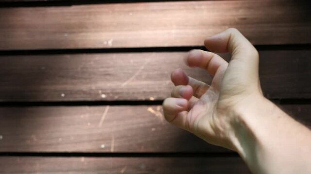 Neurodivergent person hand stimming against wooden surface