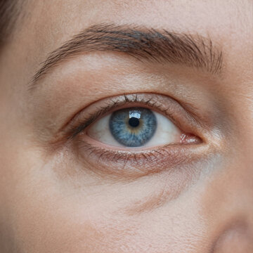 Impressionist Crow Eye. Close-Up Portrait Of A Mature Caucasian Woman'S Blue Eye With Visible Wrinkles And Crow'S Feet