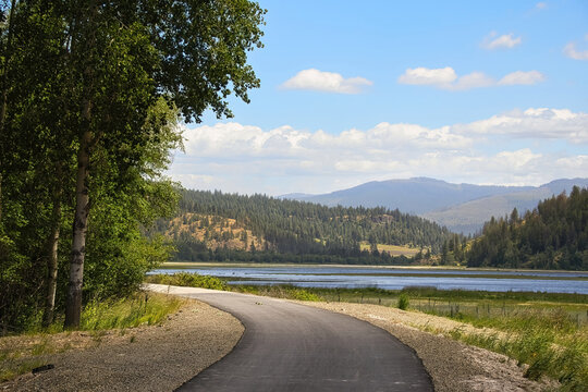 Sunny summer day view of the Trail of the Coeur d&rsquo;Alenes beside wetlands and distant mountains near Harrison, Idaho.