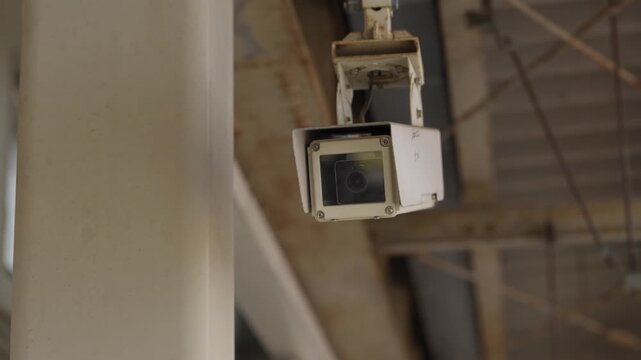 Box style security camera mounted on structure monitoring train station platform
