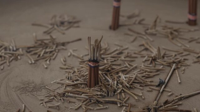 Burnt incense stick remains scattered in ash bed at Buddhist temple in Japan