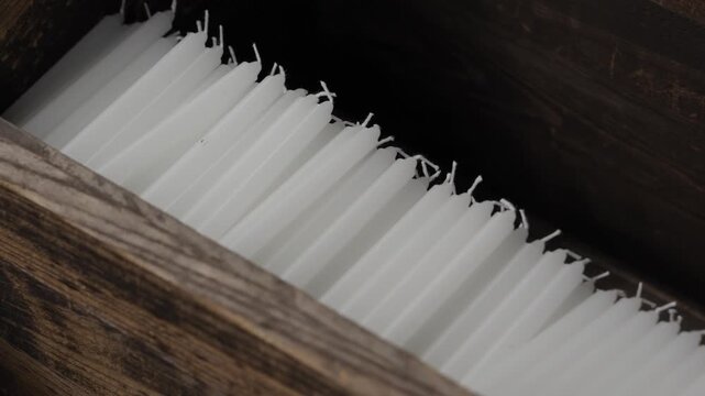 White unlit prayer candles packed in row in wooden box at Buddhist temple Japan