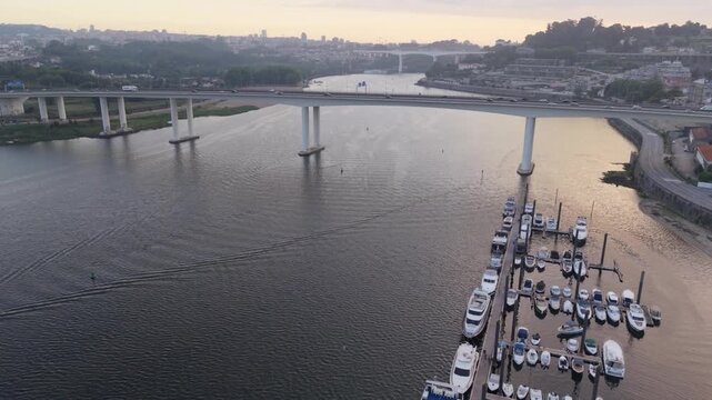 Aerial of Ponte do Freixo bridge marina and Douro River at golden sunrise in Porto