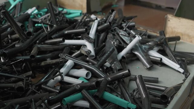 Heap of discarded plastic pipes joints and fittings collected for recycling in factory