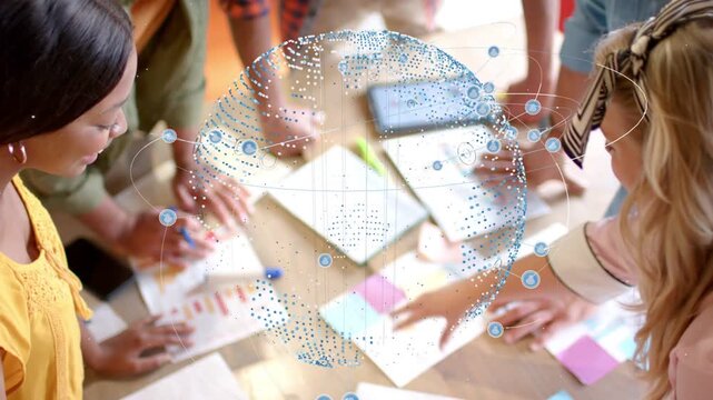 Team organizing charts and sticky notes on table while dotted sphere appearing, mapping business