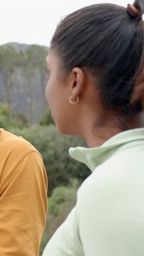 Vertical video: Talking woman in zip top pausing on trail, speaking to smiling man in yellow tee