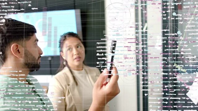Man lifting pen and pointing at glass woman watching, data overlay tagging notes for business plan
