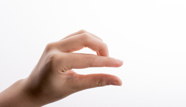 Close up of a female hand gesturing to hold or measure a small object on white background