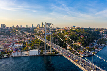 Obraz premium Bosphorus Bridge Aerial View — Suspension Bridge with Heavy Traffic Connecting Europe and Asia Over Bosphorus Strait | Istanbul City Skyline at Sunset