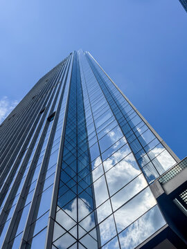 Modern skyscraper reflecting clouds on a sunny day