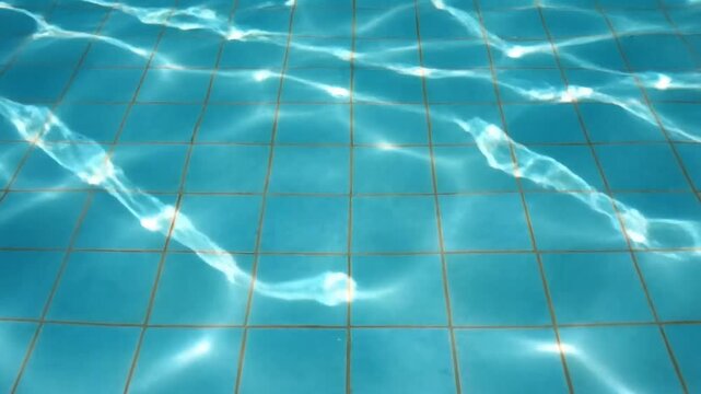Abstract swimming pool water surface with sun light caustics and tiles