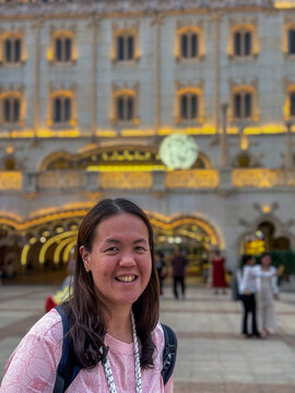 Tourist smiling in front of the venetian macao resort hotel casino building