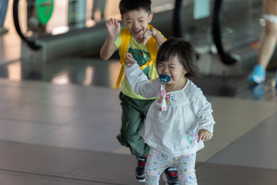 Happy children running in airport terminal while traveling