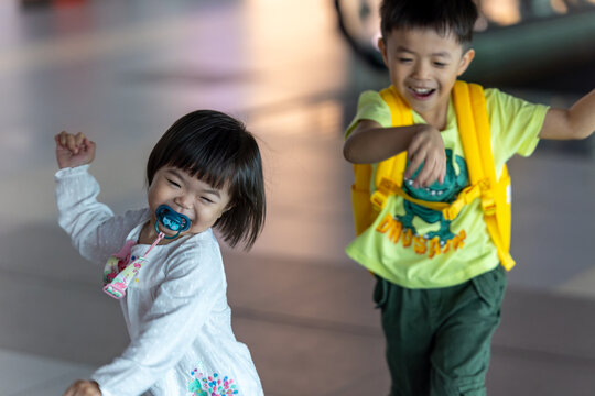 Happy children running in airport terminal while traveling