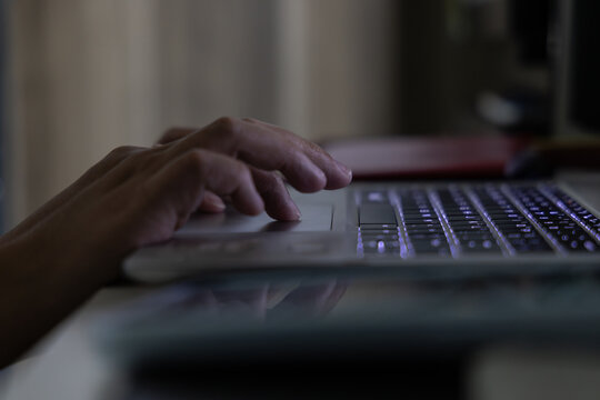 Lady Hand typing on keyboard laptop on midnight
