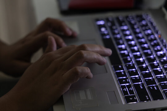 Lady Hand typing on keyboard laptop on midnight