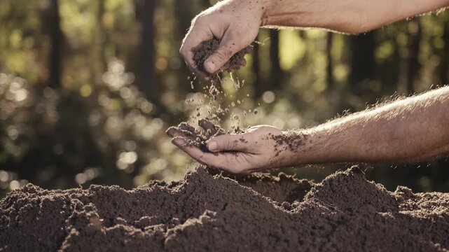 Closeup of dirt and clay in hands. Melioration concept. Earth and environment protection theme. Gardening and ecology. Hands working with soil. Close up of hands holding soil.