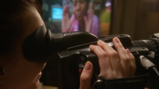 Caucasian teenage girl filming African American friend making funny faces on retro video camera, friend laughing and showing thumbs up on CRT monitor. Youth lifestyle and retro technology commercials