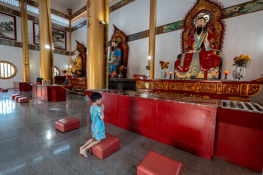 Boy praying with innocent faith in temple