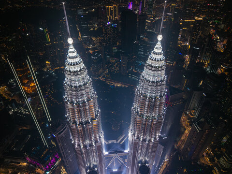 Petronas towers illuminating kuala lumpur urban cityscape at night