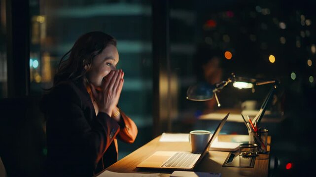Excited businesswoman looking laptop reacting emotionally on success at office