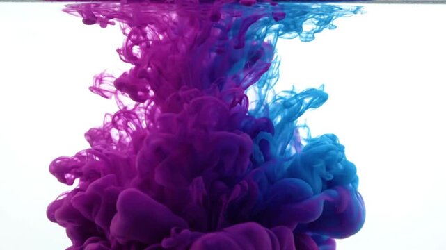 Colorful ink clouds swirling in water creating vibrant abstract art with purple and blue hues