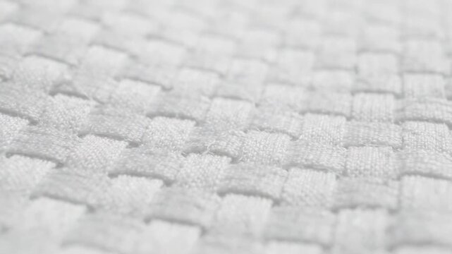 Closeup of woven fabric texture showing detailed pattern and soft white fibers