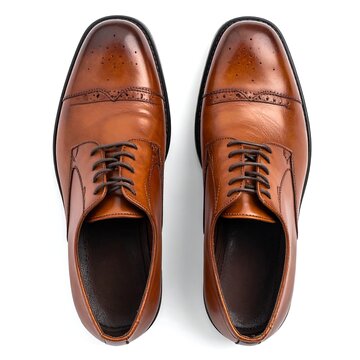A pair of brown leather dress shoes with brogue details and laces