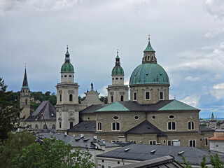 Naklejka premium Salzburg Cathedral in Salzburg, Austria from footpath to Hohensalzburg Fortress on rainy overcast summer afternoon.