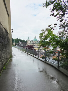 Salzburg Cathedral in Salzburg, Austria from footpath to Hohensalzburg Fortress on rainy overcast summer afternoon.