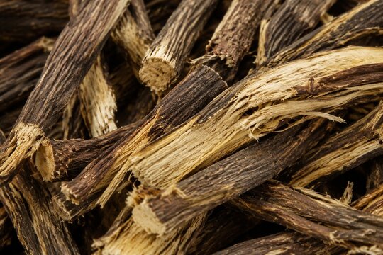 Textural detail of fibrous licorice root with interwoven brown and yellow patterns.