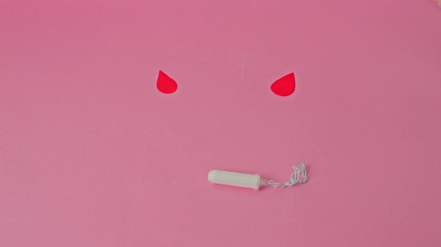 Creative period concept featuring a cotton tampon and red paper drops